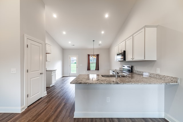 kitchen featuring dark wood-type flooring, kitchen peninsula, appliances with stainless steel finishes, and white cabinets