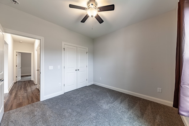 unfurnished bedroom featuring a closet, ceiling fan, and dark carpet