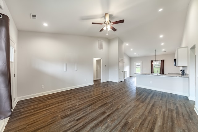 unfurnished living room featuring dark wood-type flooring, ceiling fan, and high vaulted ceiling