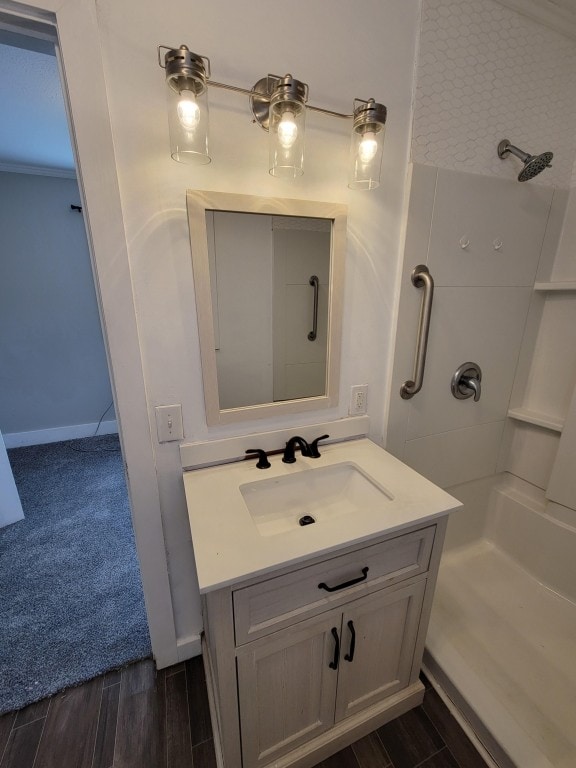 bathroom with walk in shower, hardwood / wood-style floors, and vanity