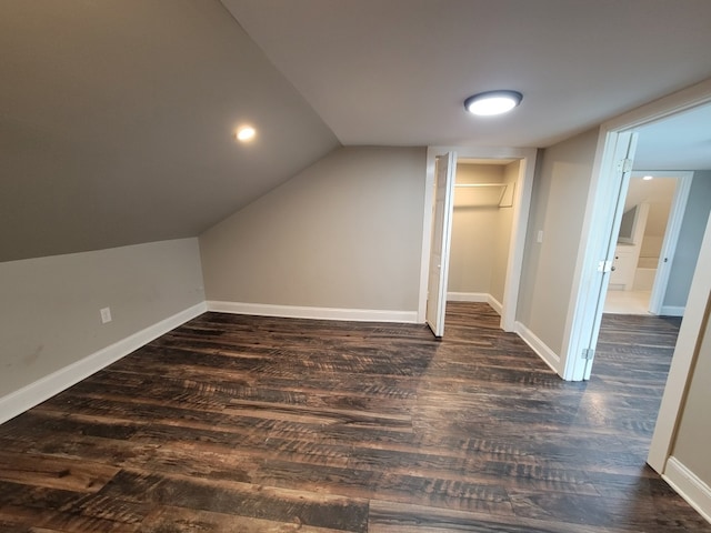 additional living space with dark wood-type flooring and vaulted ceiling