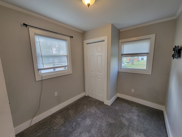 unfurnished bedroom with a closet, multiple windows, crown molding, and dark carpet