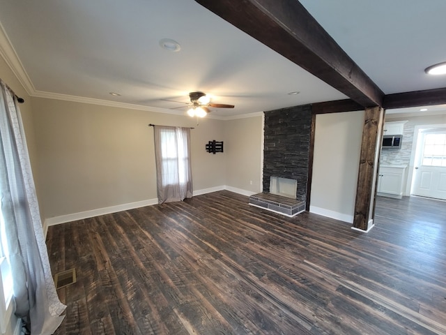 unfurnished living room featuring dark wood-type flooring, beamed ceiling, a stone fireplace, and ceiling fan