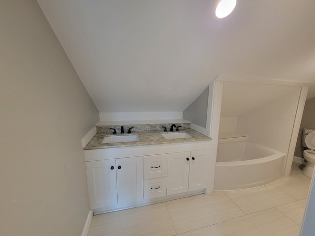 bathroom featuring tile patterned flooring, a bath, toilet, and vanity