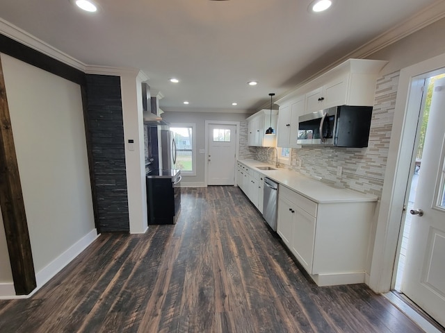 kitchen with white cabinetry, sink, appliances with stainless steel finishes, crown molding, and dark wood-type flooring