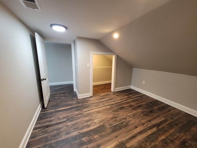 additional living space featuring dark hardwood / wood-style flooring and vaulted ceiling