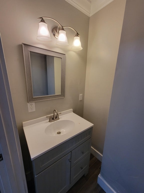 bathroom with ornamental molding, vanity, and wood-type flooring