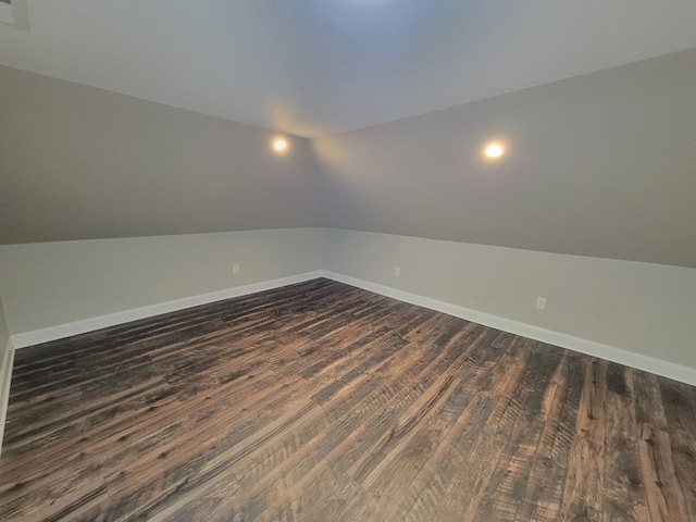 unfurnished room featuring dark hardwood / wood-style floors and vaulted ceiling