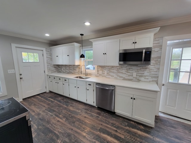 kitchen featuring stainless steel appliances, sink, plenty of natural light, decorative light fixtures, and white cabinets