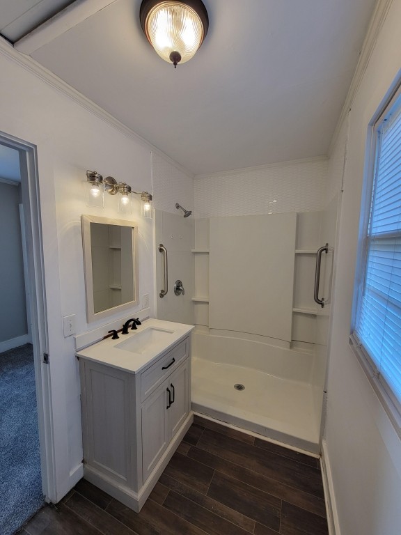 bathroom with a healthy amount of sunlight, hardwood / wood-style flooring, and a shower