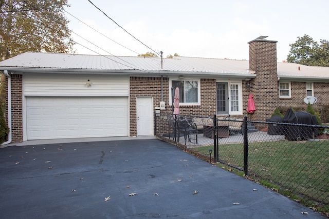 single story home with a garage and a front lawn