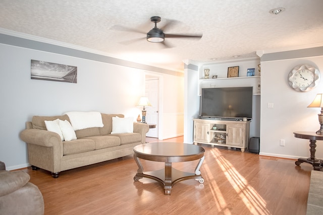 living room featuring ceiling fan, crown molding, wood-type flooring, and a textured ceiling