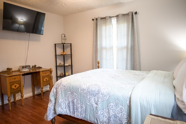 bedroom with dark wood-type flooring and a textured ceiling