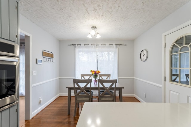 dining space with dark hardwood / wood-style floors and a textured ceiling