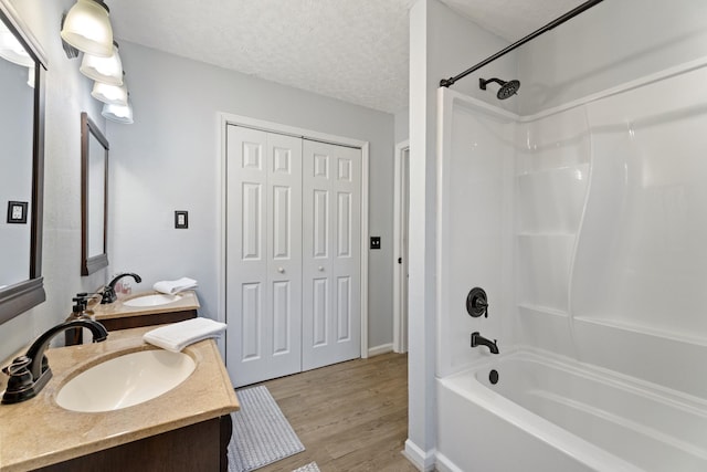 bathroom featuring vanity, hardwood / wood-style floors, tub / shower combination, and a textured ceiling