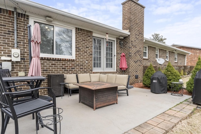 view of patio with area for grilling and an outdoor living space with a fire pit