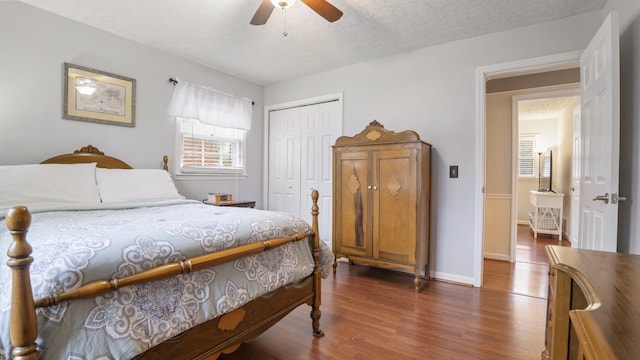 bedroom with ceiling fan, dark hardwood / wood-style floors, a closet, and a textured ceiling