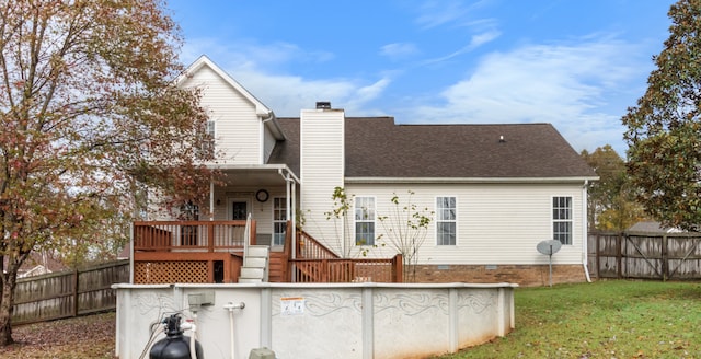 back of house featuring a wooden deck and a lawn