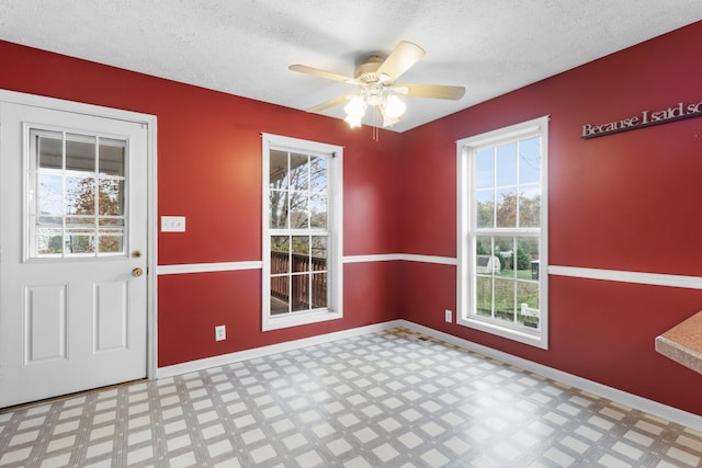 unfurnished dining area featuring a textured ceiling and ceiling fan