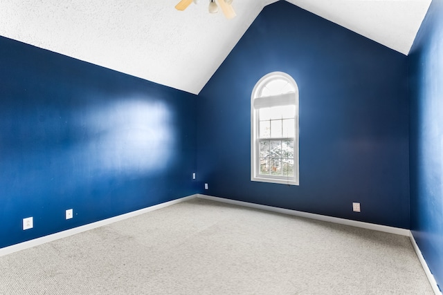 carpeted spare room featuring a textured ceiling, lofted ceiling, and ceiling fan