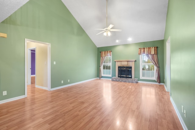 unfurnished living room featuring high vaulted ceiling, a textured ceiling, ceiling fan, and light hardwood / wood-style flooring