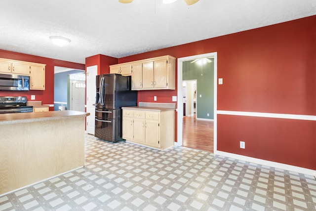 kitchen featuring ceiling fan, a textured ceiling, and appliances with stainless steel finishes