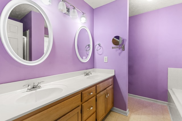 bathroom featuring a washtub, vanity, and a textured ceiling