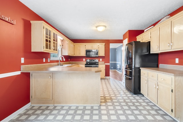 kitchen featuring stainless steel appliances, sink, kitchen peninsula, light brown cabinetry, and a textured ceiling