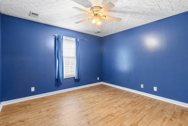 spare room featuring light hardwood / wood-style floors, ceiling fan, and a textured ceiling