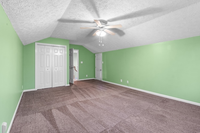 unfurnished bedroom with lofted ceiling, a textured ceiling, ceiling fan, and carpet floors