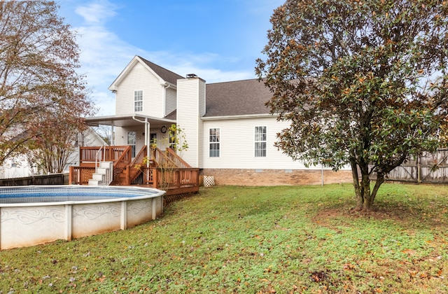 rear view of house featuring a lawn and a pool side deck