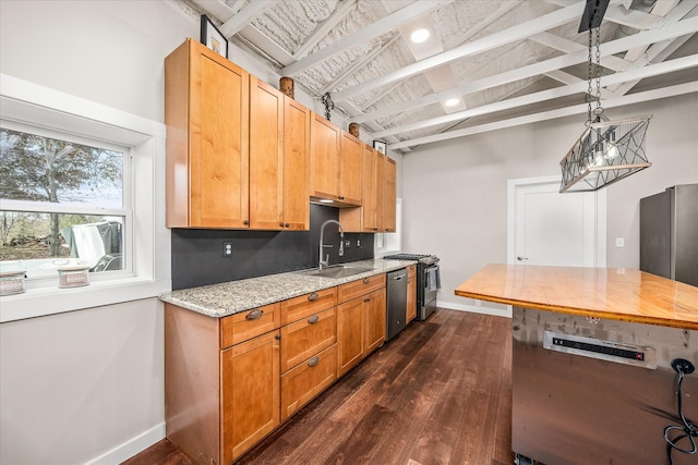 kitchen featuring light stone counters, sink, dark hardwood / wood-style floors, appliances with stainless steel finishes, and decorative light fixtures