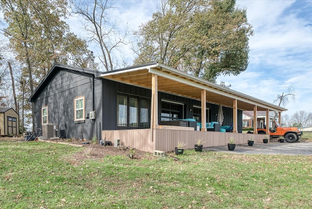 view of side of home featuring central AC unit and a yard