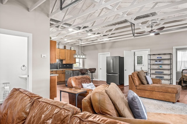 living room featuring a towering ceiling, hardwood / wood-style flooring, and sink