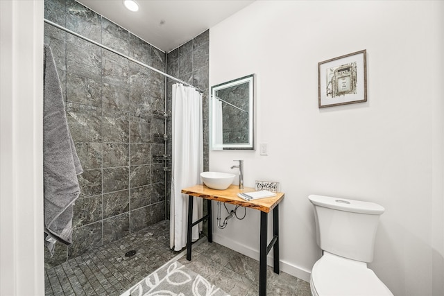 bathroom featuring a shower with shower curtain, sink, and toilet