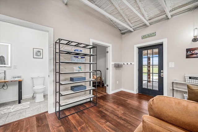 foyer featuring dark hardwood / wood-style flooring and vaulted ceiling with beams