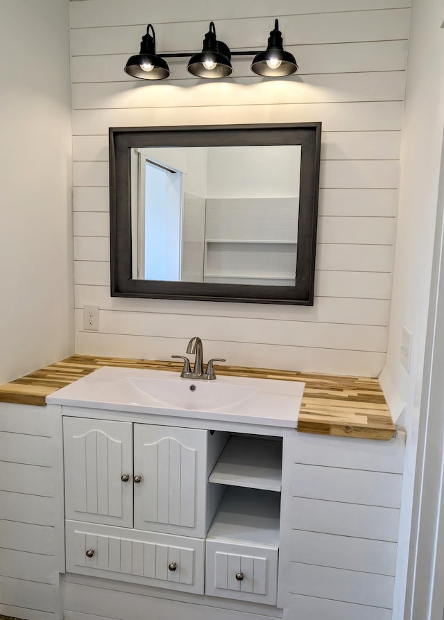 bathroom with vanity and wood walls