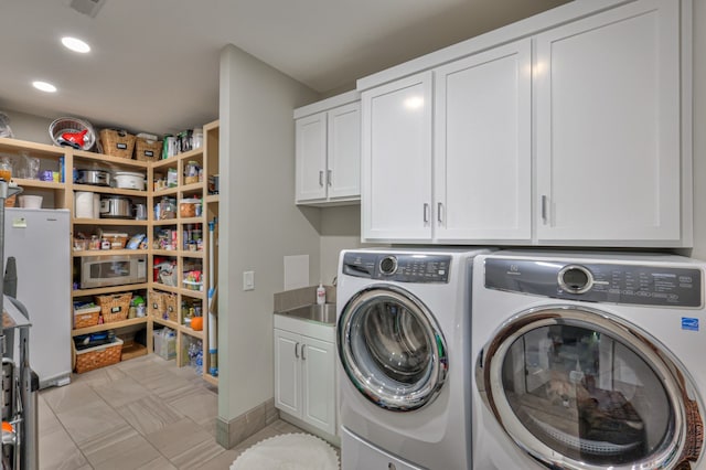 laundry area with cabinets and washer and clothes dryer