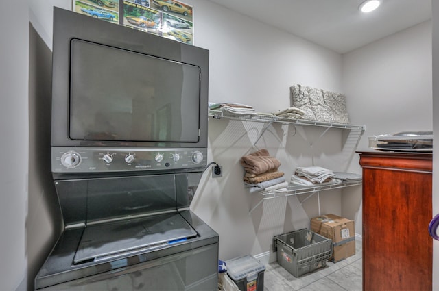 laundry area featuring stacked washing maching and dryer and light tile patterned floors