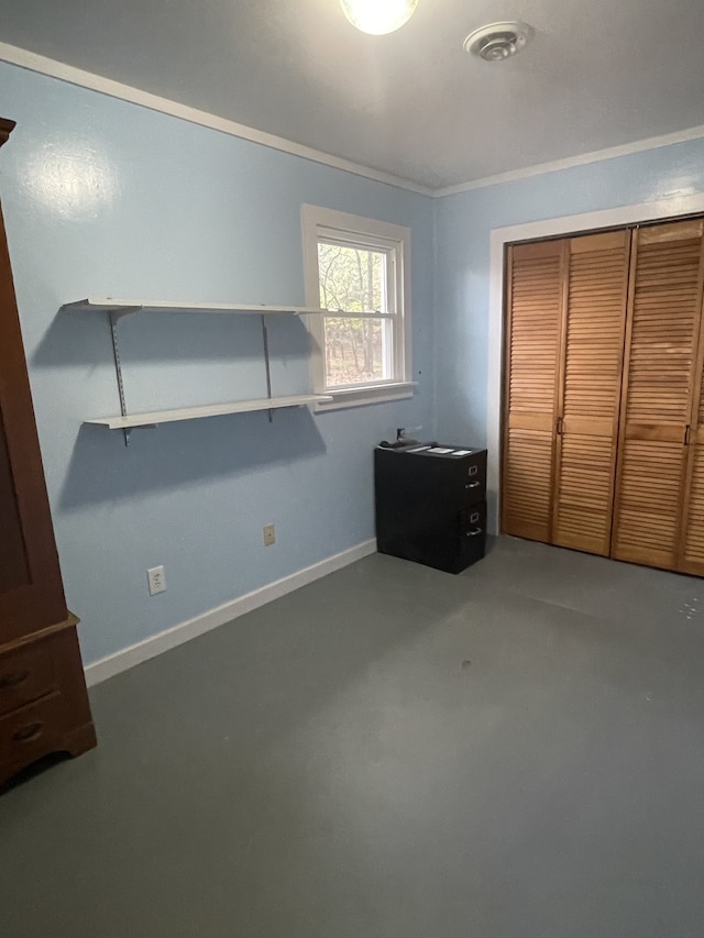 unfurnished bedroom with ornamental molding, a closet, and concrete floors