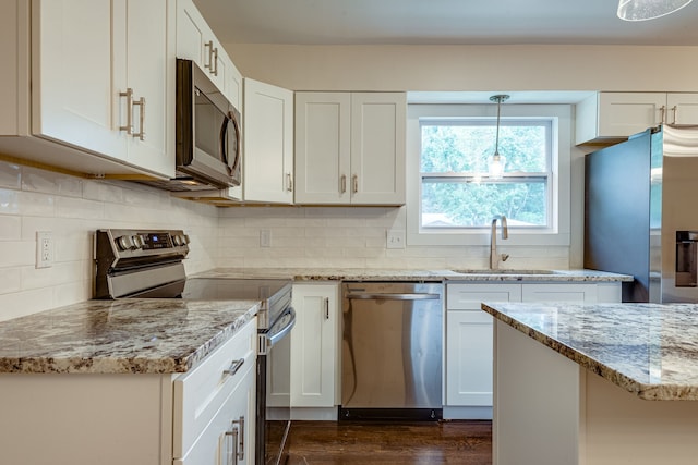 kitchen with stainless steel appliances, white cabinetry, dark hardwood / wood-style floors, light stone countertops, and sink