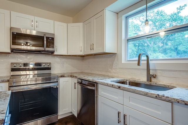 kitchen featuring plenty of natural light, sink, white cabinetry, and appliances with stainless steel finishes