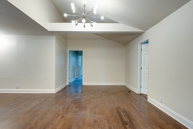 spare room featuring a chandelier, vaulted ceiling, and dark hardwood / wood-style floors