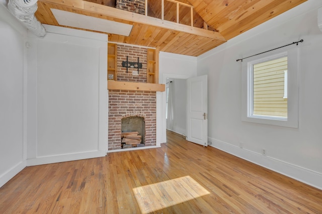 unfurnished living room featuring a fireplace, wood-type flooring, wood ceiling, and vaulted ceiling