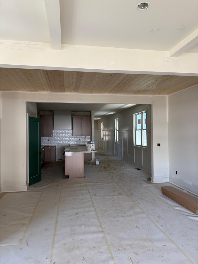 kitchen featuring open floor plan, light countertops, decorative backsplash, beam ceiling, and brown cabinets