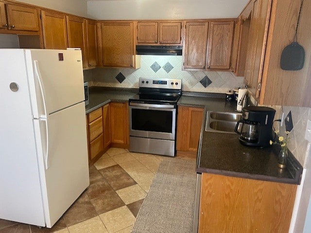 kitchen with stainless steel electric range, decorative backsplash, and white fridge