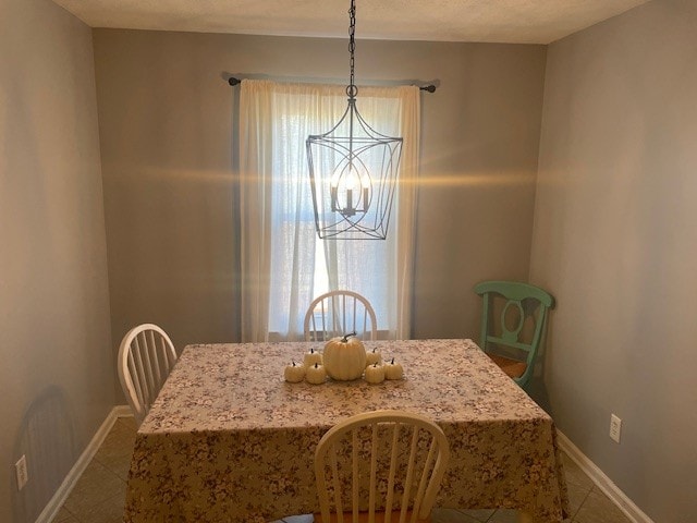 dining space featuring a chandelier and tile patterned flooring