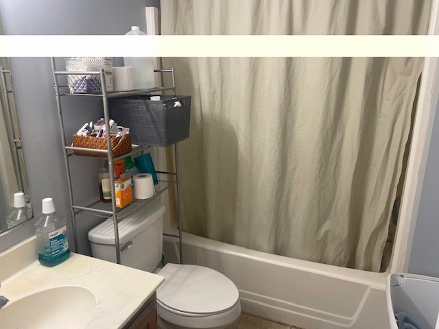 full bathroom with vanity, toilet, and shower / tub combo with curtain