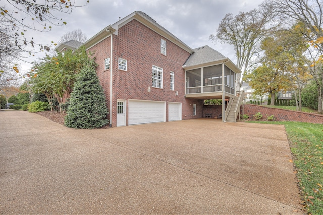 view of home's exterior featuring a garage and a sunroom