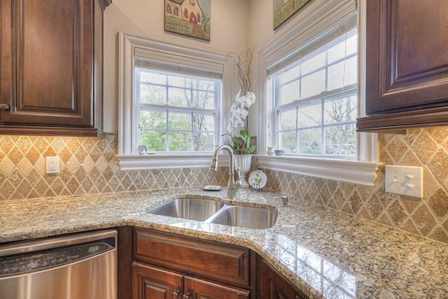 kitchen with sink, light stone countertops, and dishwasher